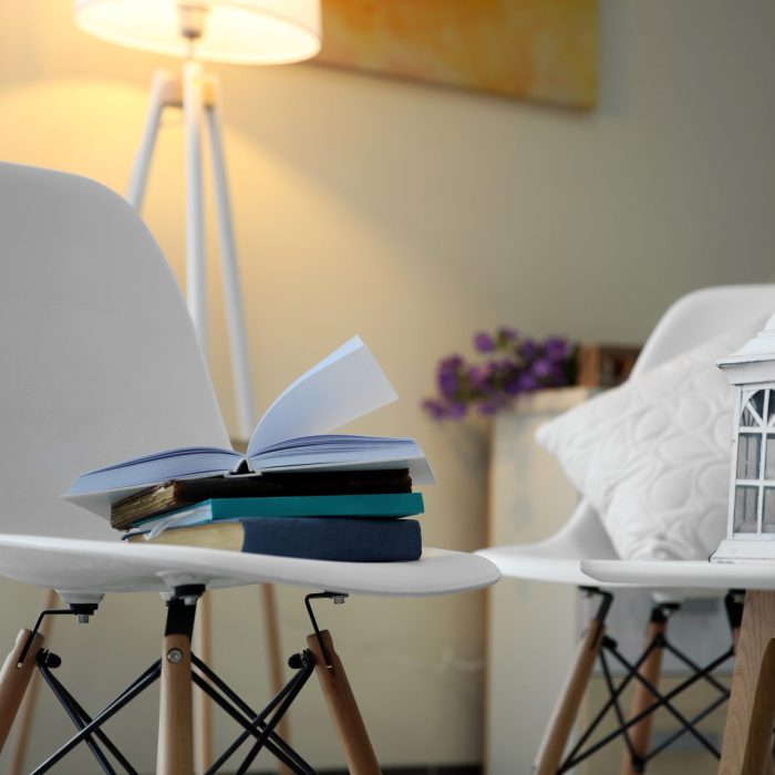 White table and chairs with books in a room